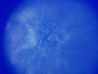 An abstract image in blue. It has a circular vignette. The image is blurry overall, however in the center there are slightly more defined spikes in white. Overall, the image is interesting, but unrecognizable.
